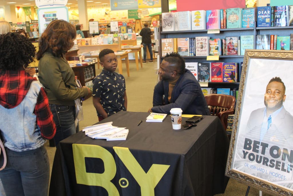 Dr. Hodges talking to a kid at his book stand